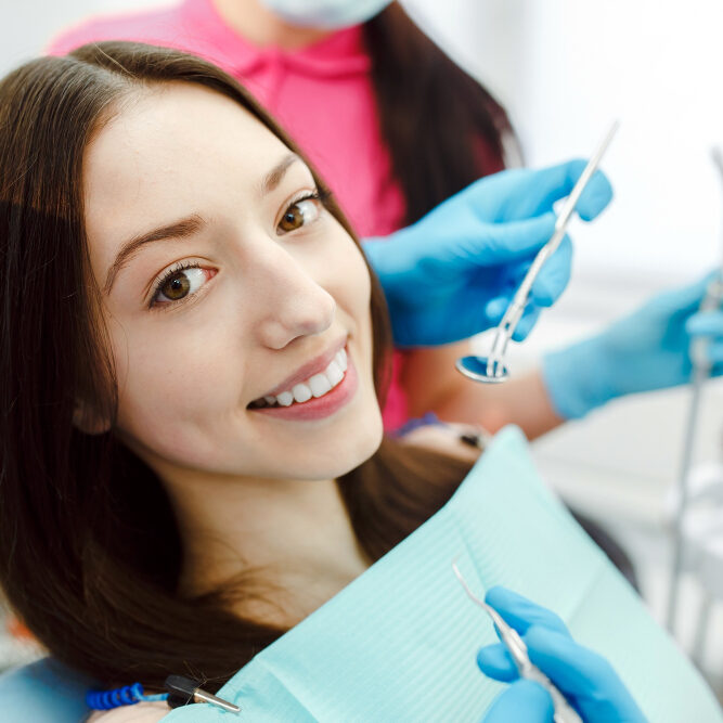 Assistant dentist and the patient in the clinic.